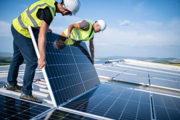 Services two workers on a rooftop installing a photovoltaic system.